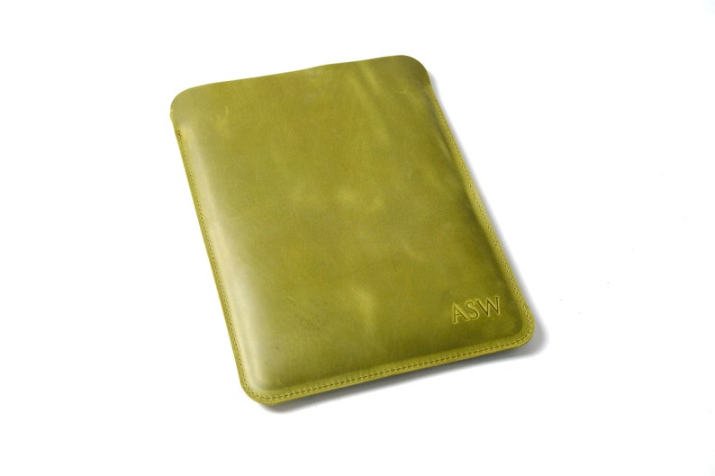 May include: A green leather case with the initials "ASW" embossed on the front.