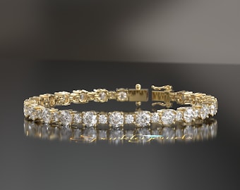 May include: A gold tennis bracelet with a row of round, clear diamonds.