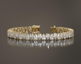 May include: A gold bracelet with a row of pear-shaped diamonds.