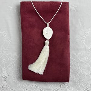 Collar con borla y colgante de fósil pulido