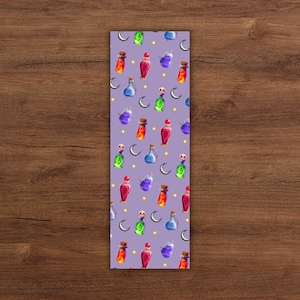 May include: A purple bookmark with a repeating pattern of colorful potion bottles, moons, and stars. The bottles are various colors, including red, green, blue, and purple, with cork stoppers. A whimsical design.
