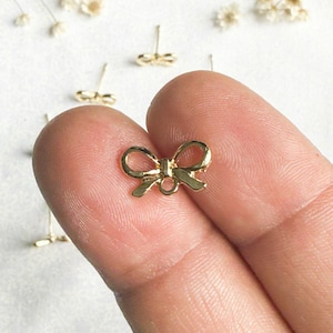 May include: Gold-toned bow charm with a loop for attaching to jewelry or other crafts.
