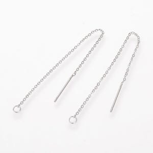 May include: A pair of silver chain earrings with a small loop at the top and a straight wire at the bottom.