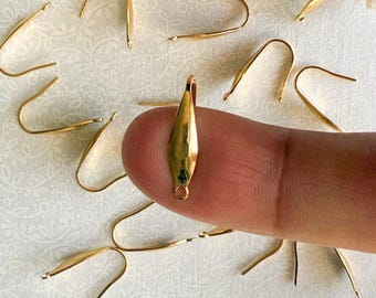 May include: Gold-toned metal earring hooks with a teardrop-shaped design. The hooks are shown on a white surface.