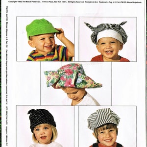 May include: A sewing pattern for making children's hats. The pattern includes five different hat styles: a green baseball cap, a white and black checkered hat, a floral sun hat, a black and white polka dot hat, and a striped sailor hat.