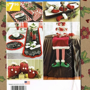 Op de afbeelding: Een Simplicity-naai-patroon voor kersttafeldecoraties. Het patroon bevat instructies voor het maken van een kerstman-tafelkleed, een elf-tafelkleed en diverse andere feestelijke tafeldecoraties. Het patroonnummer is S0149 en de prijs is € 7,96.