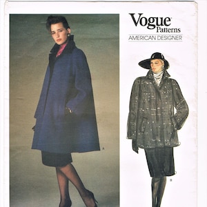 May include: Vogue Patterns American Designer sewing pattern #1434 by Oscar de la Renta. The pattern features two different styles of coats, one in a dark blue color and the other in a black and white patterned fabric.