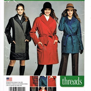 May include: Simplicity sewing pattern number 1015, size 6-14, for a long coat with a wrap style. The pattern includes three different views: a black and gray coat, a red coat, and a blue coat. The pattern is designed and printed in the USA.
