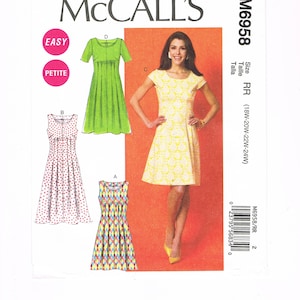 以下が含まれることがあります： McCall'sのドレス用型紙M6958。4種類のドレススタイルのイラストが含まれています。表紙には黄色のドレスを着た女性が描かれています。パターンは「Easy」と「Petite」と表示されています。