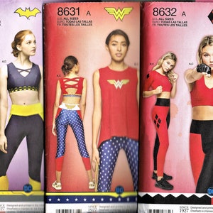 May include: Three sewing patterns for women's athletic wear featuring superhero themes. The patterns are for a red and black top with a diamond pattern, a red top with a Wonder Woman logo, and a black top with a Batman logo. Each pattern includes leggings with a matching superhero theme.