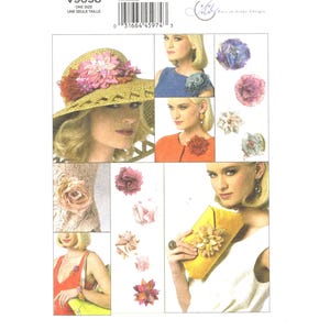 May include: A set of five flower embellishments for crafting projects. The embellishments are made of fabric and feature a variety of colors and styles, including pink, white, and blue.