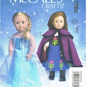 May include: A McCall's Crafts sewing pattern featuring two dolls dressed in costumes. One doll wears a light blue dress with a cape, and the other doll is in a purple cape and blue dress. The pattern number is M7065.