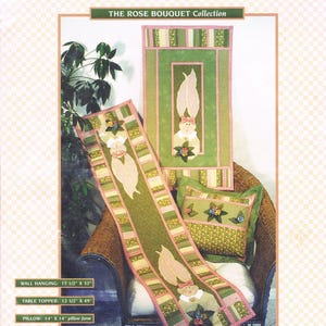 May include: A quilting pattern featuring a bunny rabbit design with pink and green fabric. The pattern includes instructions for making a wall hanging, table topper, and pillow. The text on the pattern reads "The Rose Bouquet Collection".