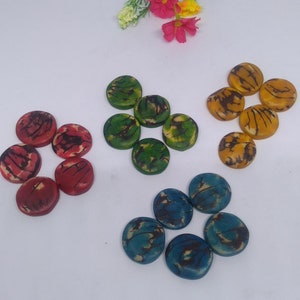 May include: Assortment of round, colorful, patterned buttons. The buttons are made of wood and have a natural, rustic look. The colors include blue, green, red, and yellow.