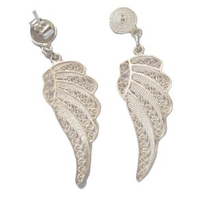 Puede incluir: Un par de pendientes de filigrana de plata con forma de alas de ángel.