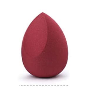 Può includere: Una spugna per il trucco a forma di lacrima di colore rosso bordeaux scuro. La spugna è realizzata in un materiale morbido e poroso ed è progettata per sfumare il trucco.