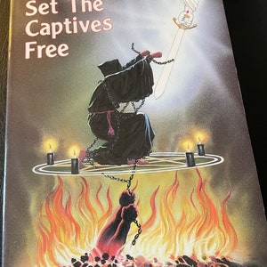May include: Book cover with the title "He Came To Set The Captives Free." The cover art depicts a robed figure kneeling in chains above flames, with a sword and a hand holding it. The author's name, Rebecca Brown, MD, is at the bottom.