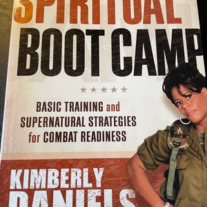 May include: A book cover with the title "SPIRITUAL BOOT CAMP" in large, bold letters. The cover also features the author's name, Kimberly Daniels, and the subtitle "BASIC TRAINING and SUPERNATURAL STRATEGIES for COMBAT READINESS."