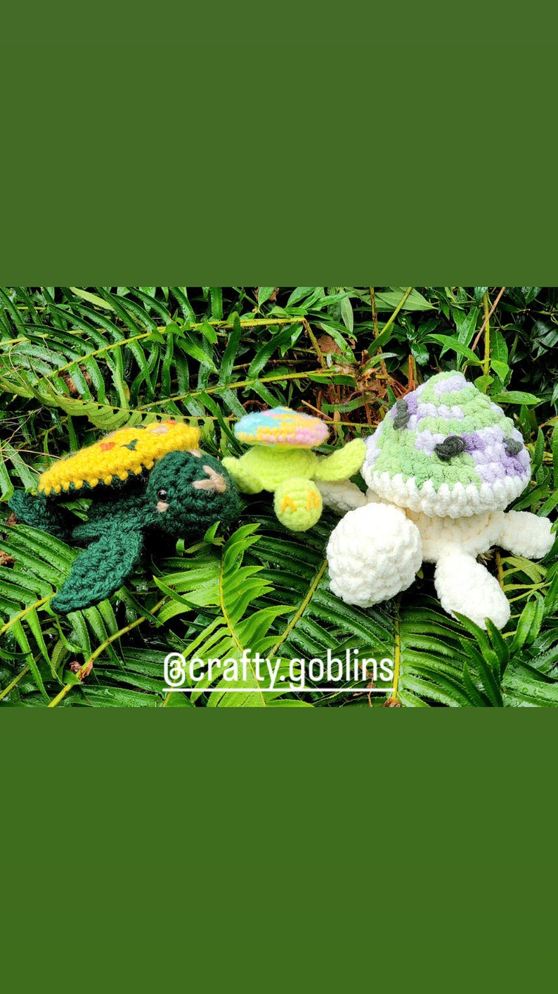 May include: Three crocheted turtle plushies. One is green with a yellow and orange shell, one is green with a rainbow shell, and one is white with a green, purple, and white shell.