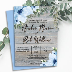 May include: A rustic wedding invitation with a woodgrain background and blue floral accents. The invitation reads "Please join friends & family to witness the wedding of Amber Marie and Rob Williams" with the date and time of the wedding: June 22, 2020 at 7:00 PM. The invitation also includes the location: The Fallbrook Inn, 118 W. Fallbrook Ln., San Diego, Calif. 92339.
