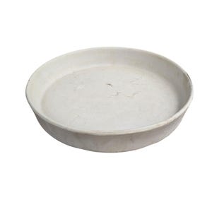 May include: A round, off-white ceramic baking dish with a shallow depth. The dish has a slightly textured surface and a simple, unadorned design. The rim is curved and the overall shape is circular.