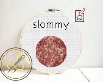 Könnte beinhalten: Ein runder Holzstickrahmen mit weißem Aida-Stoff und einem Kreuzstichmuster. Das Design zeigt den schwarzen Schriftzug 'slommy' über einem kreisförmigen, verpixelten Muster in Braun-, Beige- und Rosatönen. Ein PDF-Symbol ist zu sehen.