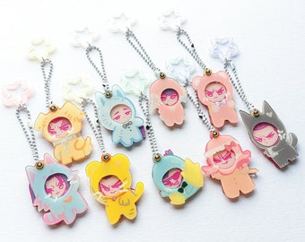 May include: A collection of acrylic keychains featuring cartoon characters in animal costumes. Each keychain has a silver chain and a star-shaped clasp. The characters are in various colors, including yellow, blue, pink, and gray.