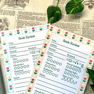May include: Two printable book review templates with a yellow and white gingham pattern and a border of red and yellow flowers. The templates have spaces to fill in the title, author, genre, plot, characters, romance, world building, writing style, spice level, and notes. The templates also have a rating system for each category.