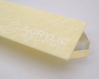 May include: A close-up of a sheet of translucent, pale yellow acrylic with a marbled pattern. The sheet has the text "Acrylic United States" printed on it.