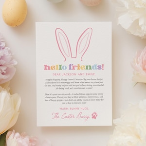 Puede incluir: Una tarjeta de felicitación crema con el texto "hello friends!" y un gráfico de orejas de conejo. La tarjeta está rodeada de huevos y flores de colores pastel. La tarjeta incluye un mensaje del Conejo de Pascua.