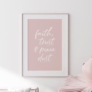 以下が含まれることがあります： ピンクの背景に白い文字で「faith, trust & pixie dust」と書かれた額装されたプリントです。