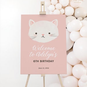 Könnte beinhalten: Rosa Willkommens-Schild mit einer weißen Katzenillustration und dem Text "Willkommen zu Adelyn's 6th Birthday June 12, 2024".
