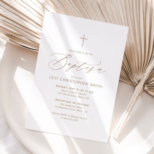 May include: A white card with a gold cross at the top and the word "Baptism" in cursive script. The card is an invitation to a baptism for Levi Christopher Smith, with the date, time, and location of the ceremony and reception.