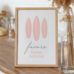 Może przedstawiać: Ramka z białym tłem i różowymi deskami surfingowymi. Na ramce napis "favors please take one".