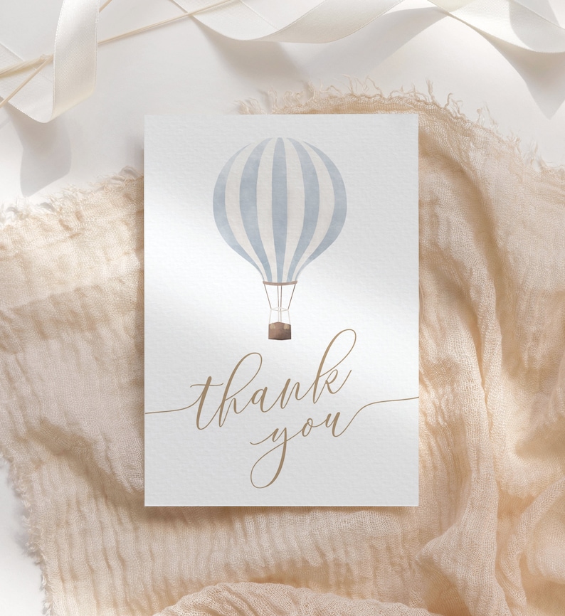 May include: A white card with a blue and white striped hot air balloon illustration and the text "thank you" in brown cursive.
