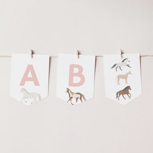 May include: A pink and white banner with the letters A and B, each with a horse illustration. The horses are white, brown, and tan.