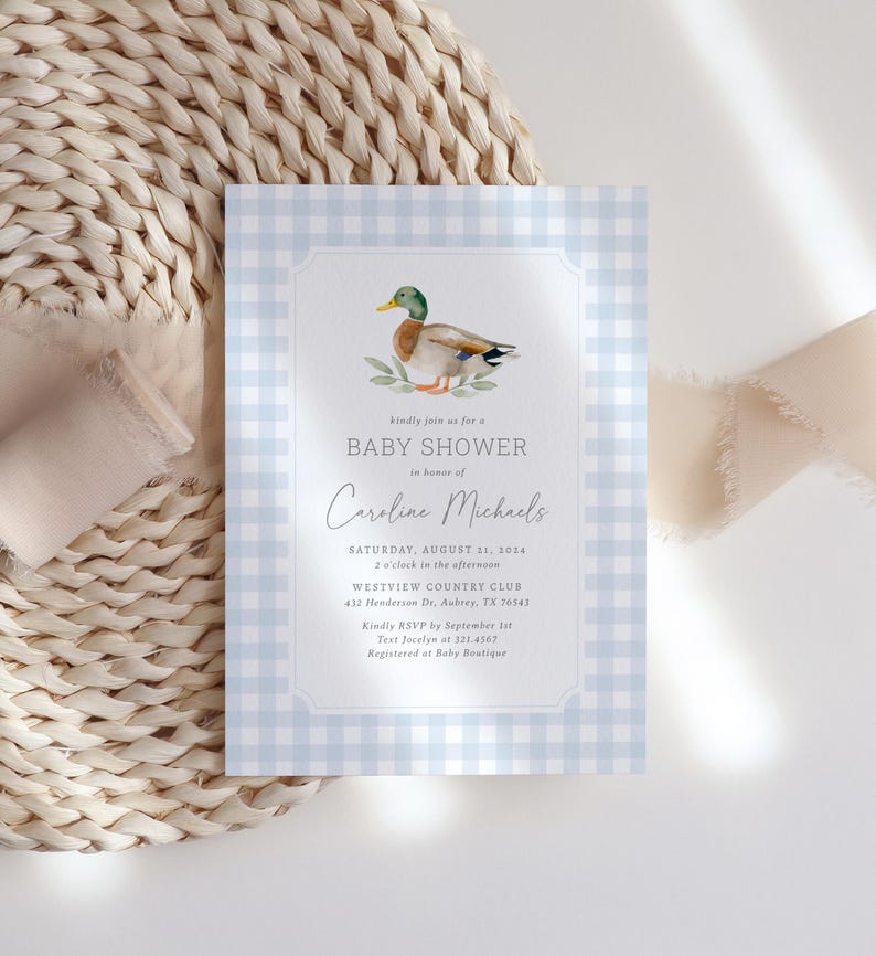 May include: A blue and white gingham baby shower invitation with a watercolor illustration of a duck. The invitation text reads "Kindly join us for a Baby Shower in honor of Caroline Michaels. Saturday, August 21, 2014, 2 o'clock in the afternoon, Westview Country Club, 432 Henderson Dr. Aubrey, TX 76543. Kindly RSVP by September 1st, Text Jocelyn at 321.4567, Registered at Baby Boutique."