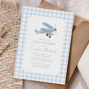 Könnte beinhalten: Eine blaue und weiße Gingham-Babyparty-Einladung mit einer blauen Flugzeugillustration. Die Einladung lautet: "Bitte nehmen Sie an unserer Babyparty zu Ehren von Caroline Michaels teil. Samstag, 21. August 2024, 14:00 Uhr, Westview Country Club, 432 Henderson Dr., Aubrey, TX 76543. Bitte melden Sie sich bis zum 10. August an. Senden Sie eine SMS an Jocelyn unter 321.4567. Geschenke können bei Baby Boutique registriert werden."