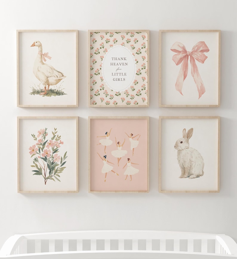 May include: A collection of six framed art prints with a nursery theme. The prints feature watercolor illustrations of a goose with a bow, a pink bow, flowers, ballerinas, a rabbit, and text that reads "Thank Heaven for Little Girls."