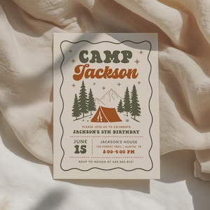May include: A rectangular birthday invitation card with a wavy border, featuring the text Camp Jackson, a graphic of a tent, pine trees, and mountains. The card includes event details for Jackson's 5th birthday on June 15 at 2:00-4:00 PM in Austin, TX.