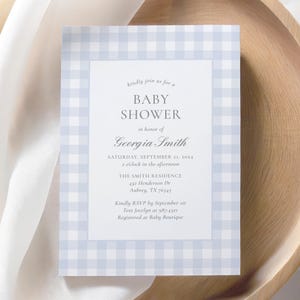 May include: A blue and white gingham baby shower invitation with the text "kindly join us for a BABY SHOWER in honor of Georgia Smith" and details for the event.