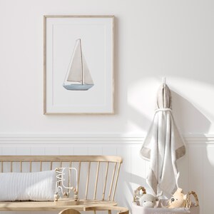 May include: A framed watercolour painting of a sailboat with a white sail and a light blue hull. The painting is set against a white background.