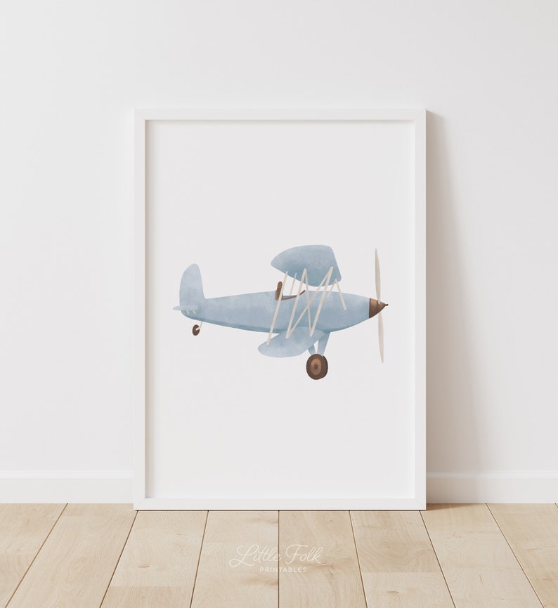 K&ouml;nnte beinhalten: Eine Aquarell-Illustration eines hellblauen Doppeldeckers mit braunem Propeller und R&auml;dern. Das Flugzeug fliegt vor einem wei&szlig;en Hintergrund.