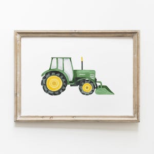 May include: Watercolor illustration of a green tractor with yellow wheels and a front loader, set against a white background. The artwork is framed in a light brown, rustic-style frame, suitable for children's room decor.