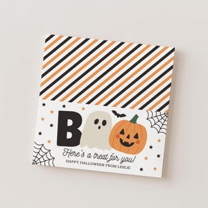 May include: A square Halloween card featuring diagonal orange, black, and white stripes at the top. The bottom section displays a white background with a black letter B, a beige ghost, an orange jack-o'-lantern, spiderwebs, and stars. Text reads: BOO Here's a treat for you! HAPPY HALLOWEEN FROM LESLIE.