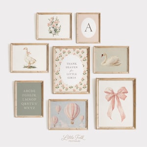 May include: A collection of framed art prints with a vintage aesthetic. The prints feature floral arrangements, a swan, a goose, a pink bow, hot air balloons, an initial, and the text "Thank Heaven for Little Girls". The color palette includes soft pinks, greens, and creams.