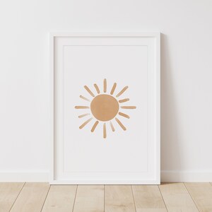 Puede incluir: Una impresi&oacute;n enmarcada de un dise&ntilde;o de sol minimalista. El sol es una forma simple dibujada a mano en un color marr&oacute;n claro.