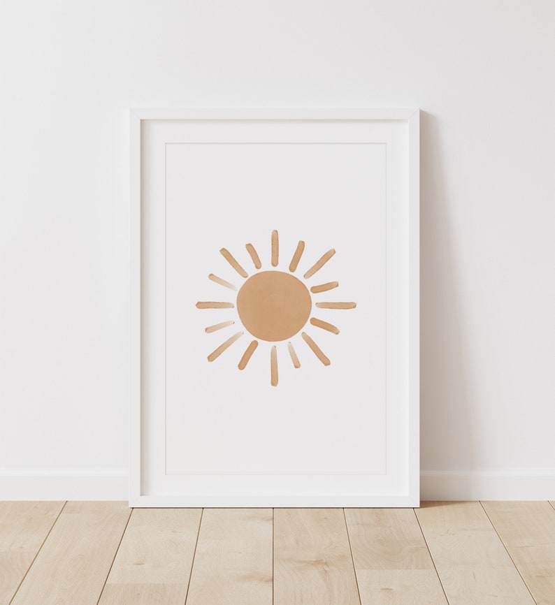 Puede incluir: Una impresi&oacute;n enmarcada de un dise&ntilde;o de sol minimalista. El sol es una forma simple dibujada a mano en un color marr&oacute;n claro.