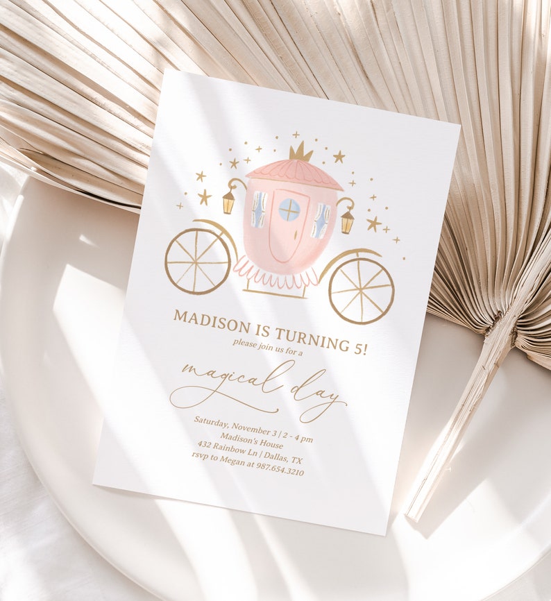 May include: A pink and gold carriage with a crown on top, surrounded by gold stars. The text "MADISON IS TURNING 5!" is written in gold lettering. The text "please join us for a magical day" is written in cursive gold lettering. The text "Saturday, November 3 | 2-4 pm" is written in gold lettering. The text "Madison's House" is written in gold lettering. The text "432 Rainbow Ln | Dallas, TX" is written in gold lettering. The text "rsvp to Megan at 987.654.3210" is written in gold lettering.