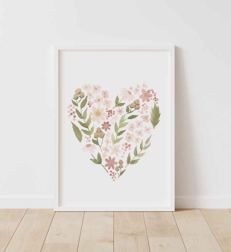 May include: A white framed print with a watercolor illustration of a heart shape made of pink, white, and green flowers.